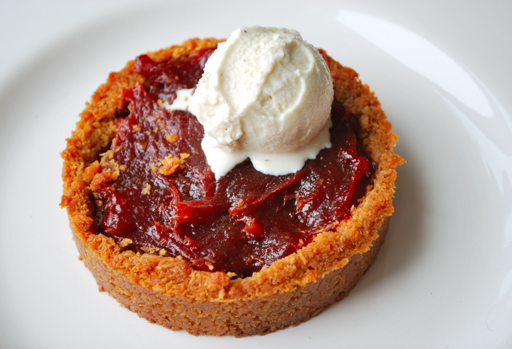 A small tart with a crust made from Choomi Naturals coconut macaroons filled with Guava preserves and topped with vanilla ice cream. 