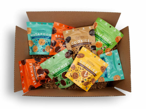 Photo of a top down view of an open box showing it full of eight packages of Choomi cookies and brownies