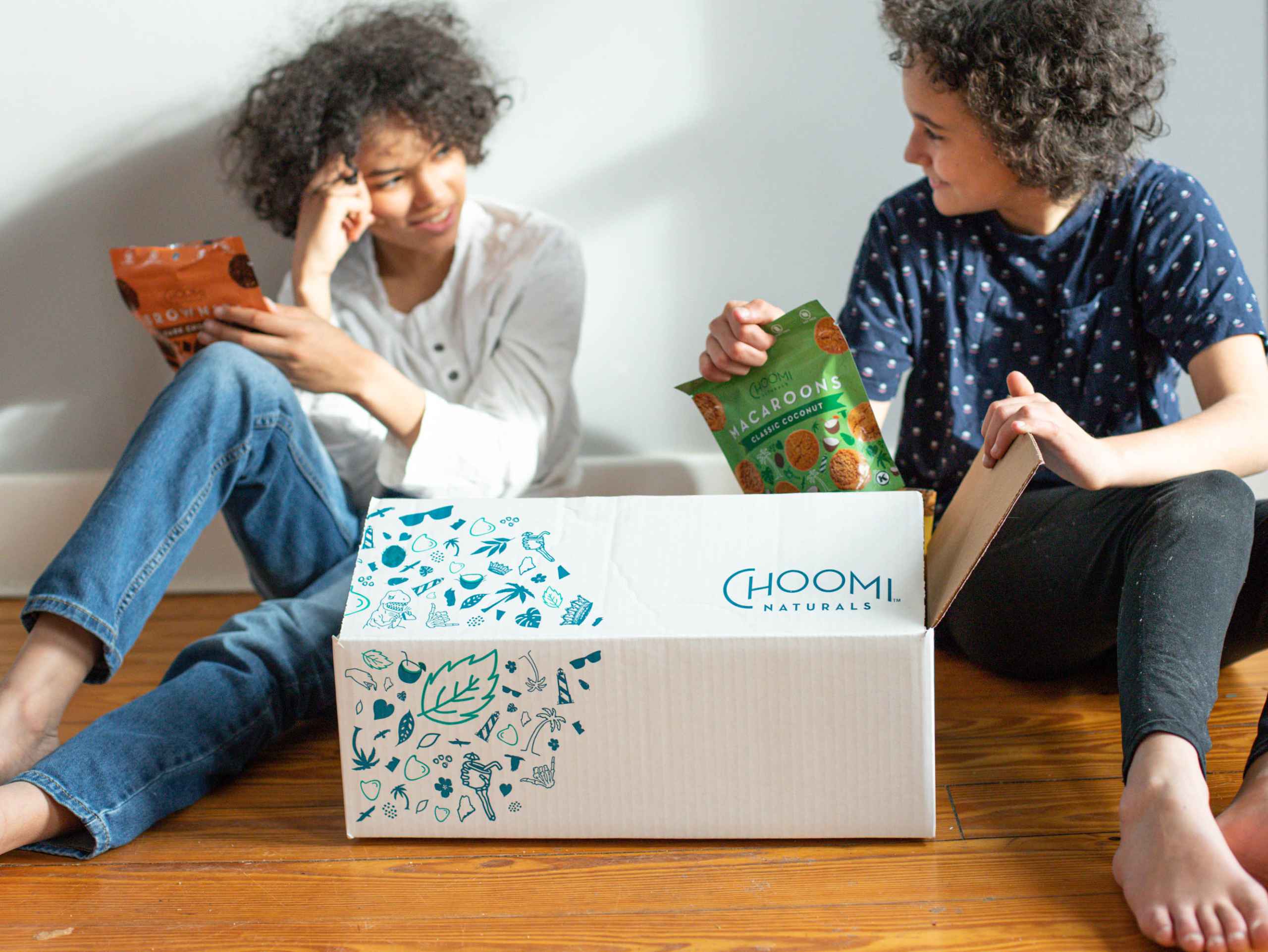 Choomi box delivered and two young woman unbox the snacks